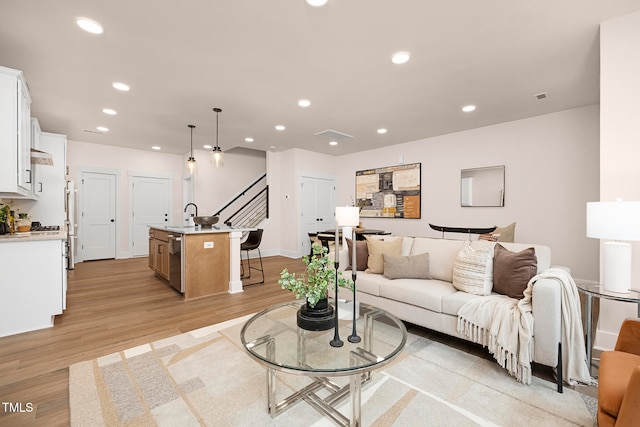 living room featuring light hardwood / wood-style floors and sink