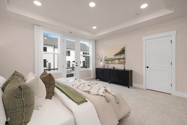 carpeted bedroom with a raised ceiling