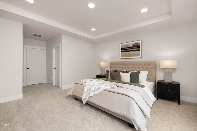 carpeted bedroom with a tray ceiling