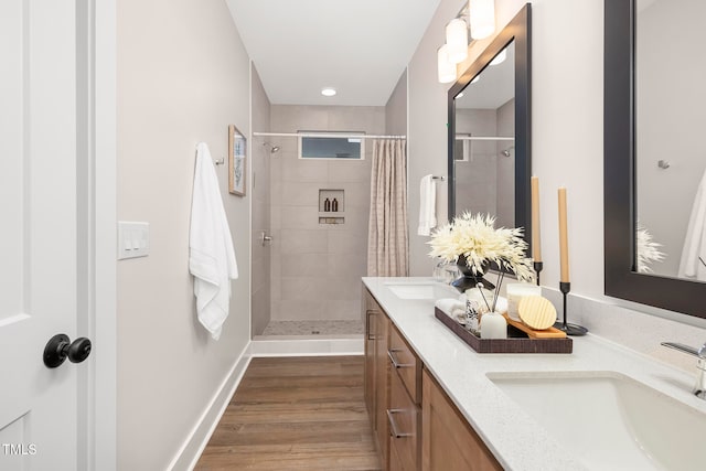 bathroom with walk in shower, vanity, and wood-type flooring