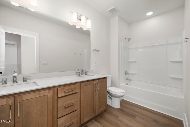 full bathroom with toilet, tub / shower combination, hardwood / wood-style flooring, and vanity