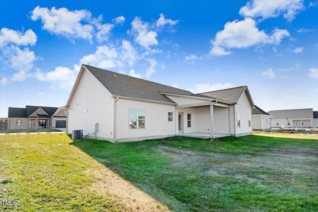 back of house featuring central AC and a lawn