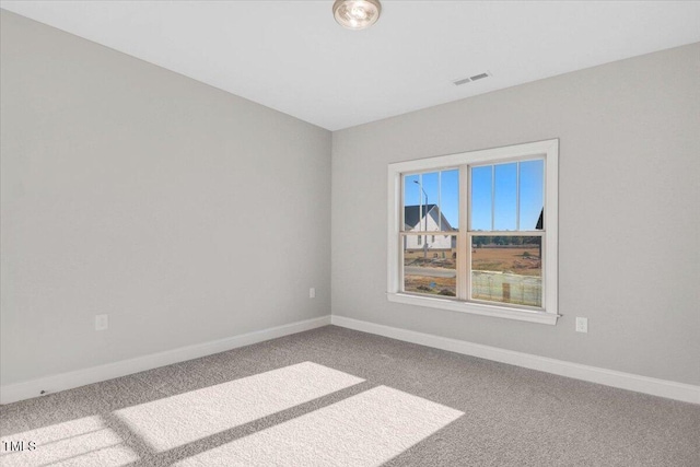 carpeted spare room featuring visible vents and baseboards