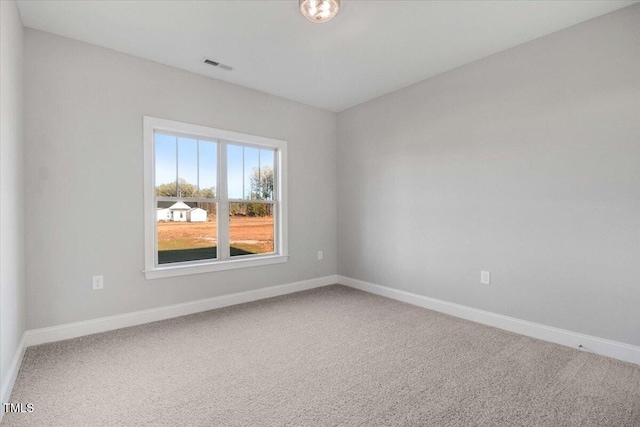 carpeted spare room featuring visible vents and baseboards