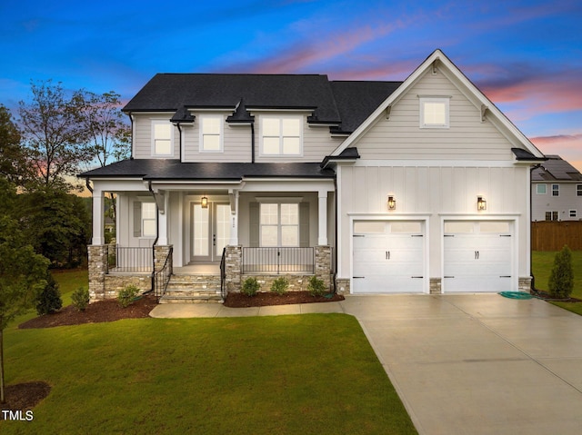 craftsman-style house with a garage, covered porch, and a lawn