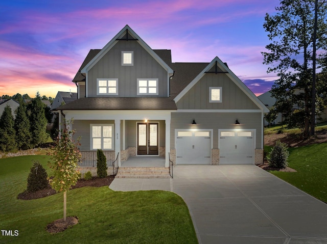 view of front facade with a garage, a yard, and covered porch