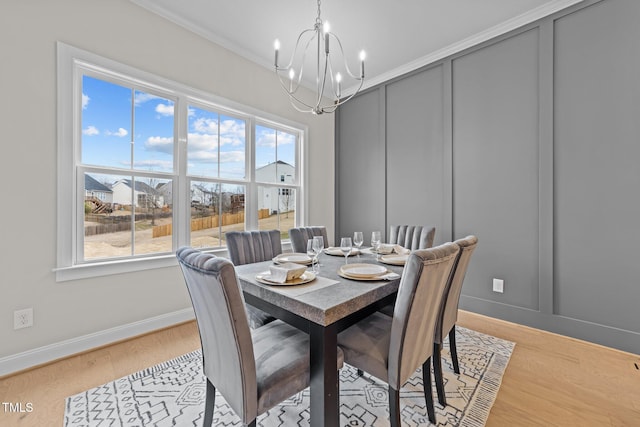 dining space featuring crown molding, light hardwood / wood-style floors, and a chandelier