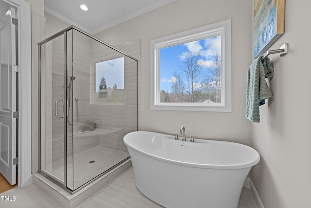 bathroom featuring ornamental molding and separate shower and tub