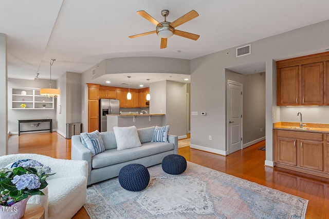 living room featuring hardwood / wood-style flooring, sink, and ceiling fan