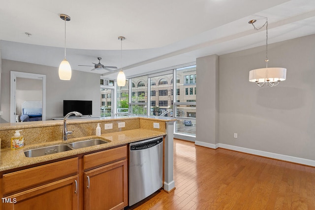 kitchen featuring light hardwood / wood-style flooring, light stone counters, decorative light fixtures, dishwasher, and ceiling fan