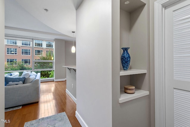 corridor featuring lofted ceiling and hardwood / wood-style floors