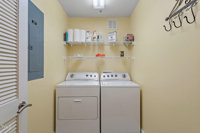 clothes washing area with washer and clothes dryer and electric panel