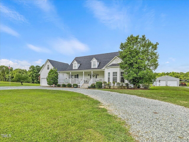 view of front of property featuring a garage, a front lawn, and covered porch