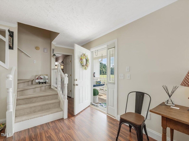 foyer featuring crown molding, hardwood / wood-style floors, and a textured ceiling