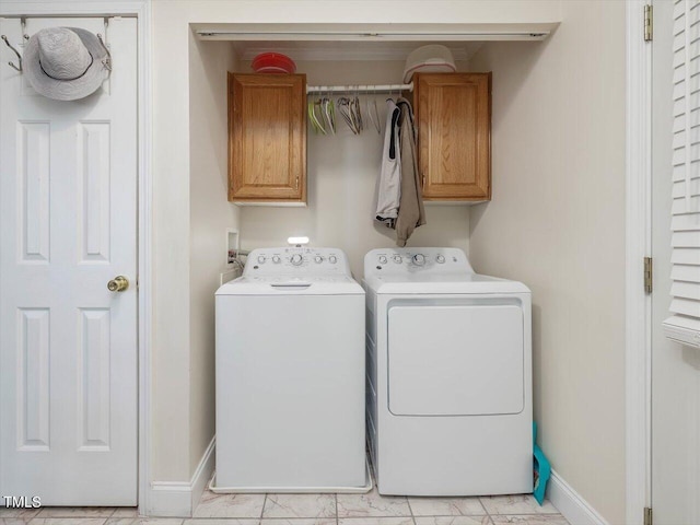 clothes washing area featuring independent washer and dryer and cabinets