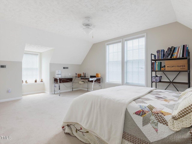 carpeted bedroom featuring vaulted ceiling and a textured ceiling