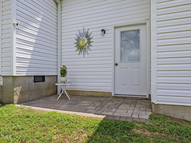 view of exterior entry featuring a patio area