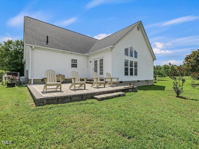 rear view of house with a patio, a lawn, and french doors