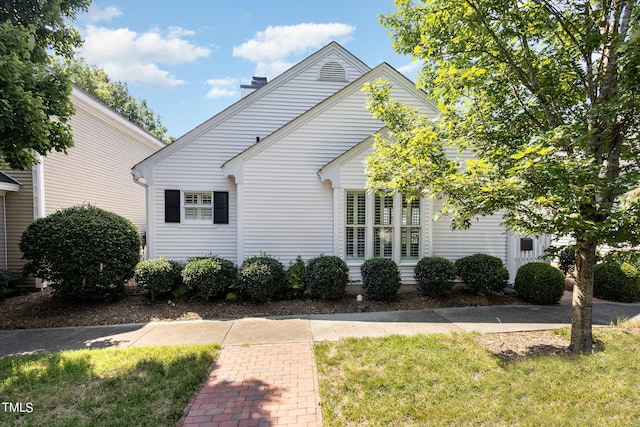 traditional home with a front yard and a chimney