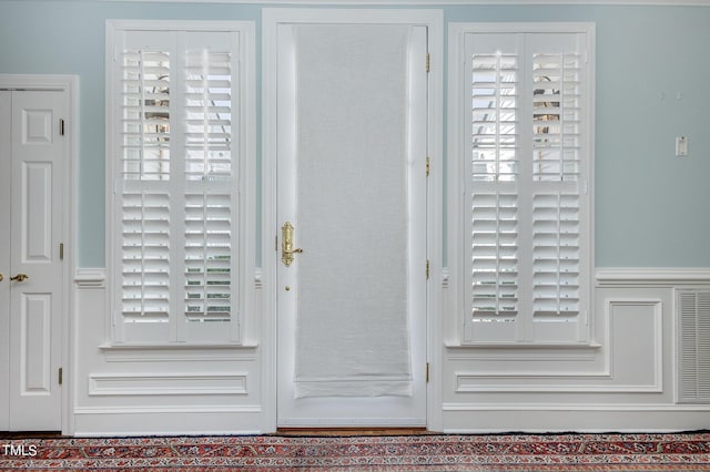 doorway with a wainscoted wall and a wealth of natural light