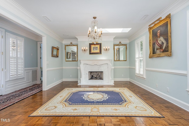 living area featuring baseboards, a premium fireplace, a chandelier, and ornamental molding