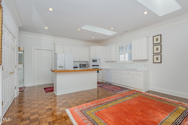 kitchen featuring white appliances, white cabinets, a kitchen island, dark parquet flooring, and a skylight