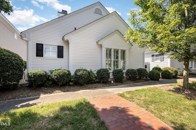 view of property exterior featuring a yard and a chimney