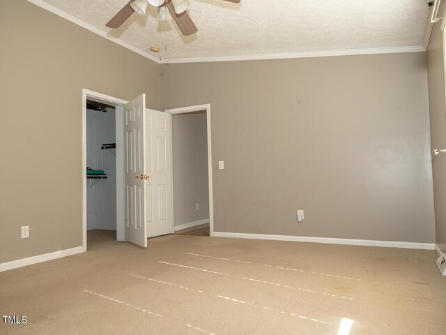 unfurnished bedroom with a textured ceiling, ceiling fan, crown molding, and carpet floors