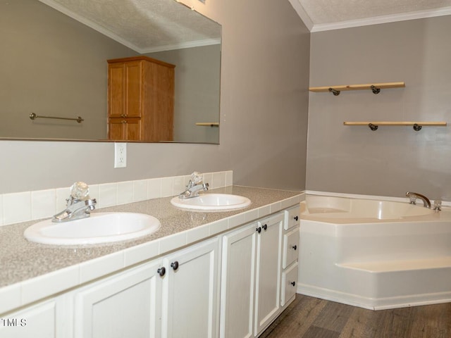 bathroom with ornamental molding, a bathtub, hardwood / wood-style floors, and vanity