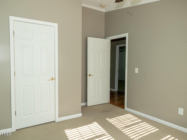 unfurnished bedroom featuring light carpet and crown molding