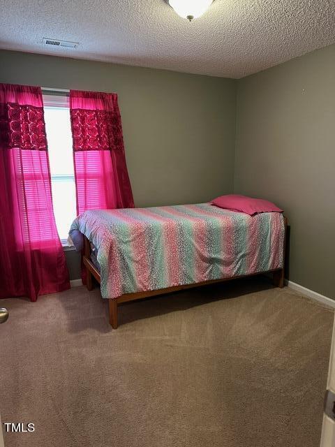 carpeted bedroom featuring a textured ceiling