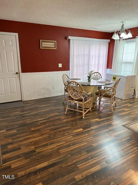 dining room featuring a notable chandelier, a textured ceiling, and dark hardwood / wood-style floors