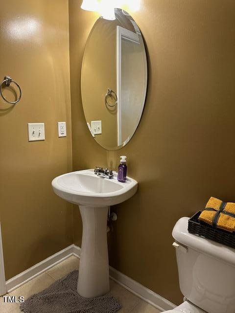 bathroom with toilet and tile patterned floors