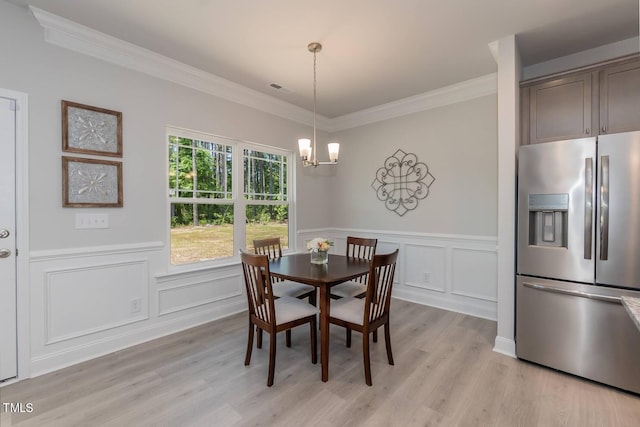 dining room with a chandelier, light hardwood / wood-style flooring, and ornamental molding