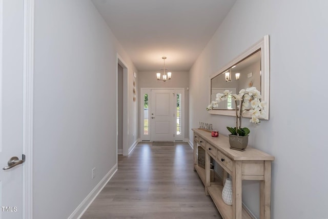 entryway with an inviting chandelier and light hardwood / wood-style floors