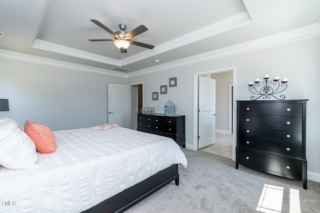 carpeted bedroom featuring baseboards, visible vents, and a raised ceiling