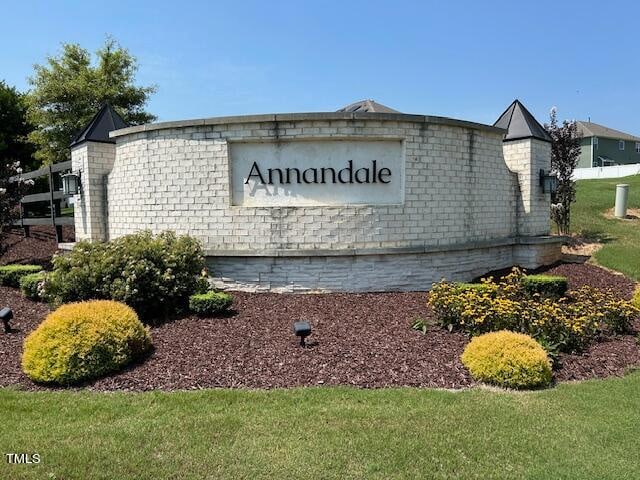 community / neighborhood sign featuring a lawn