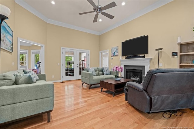 living room with ceiling fan, french doors, crown molding, and light hardwood / wood-style flooring