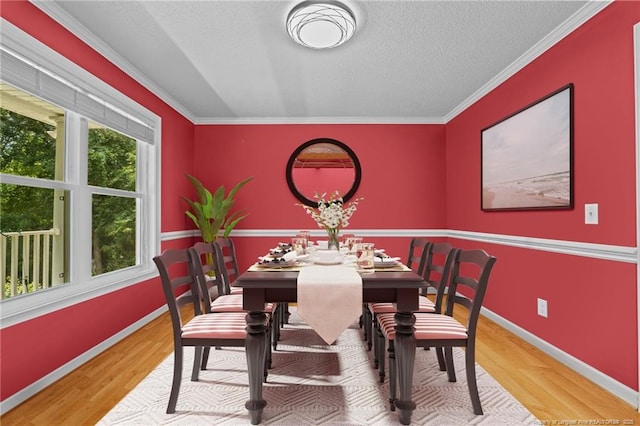 dining area featuring a textured ceiling, ornamental molding, and wood-type flooring