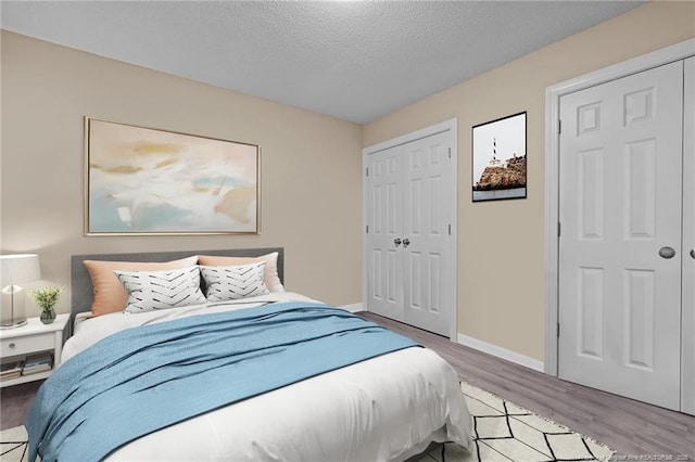 bedroom with a textured ceiling and light hardwood / wood-style flooring