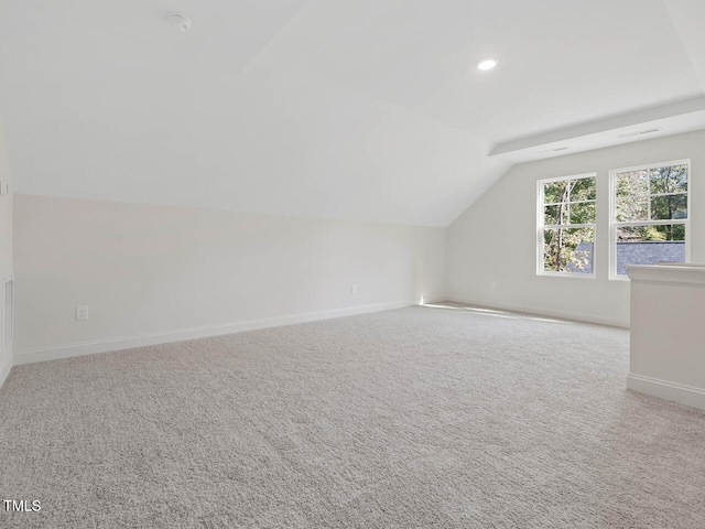 additional living space featuring lofted ceiling and light colored carpet