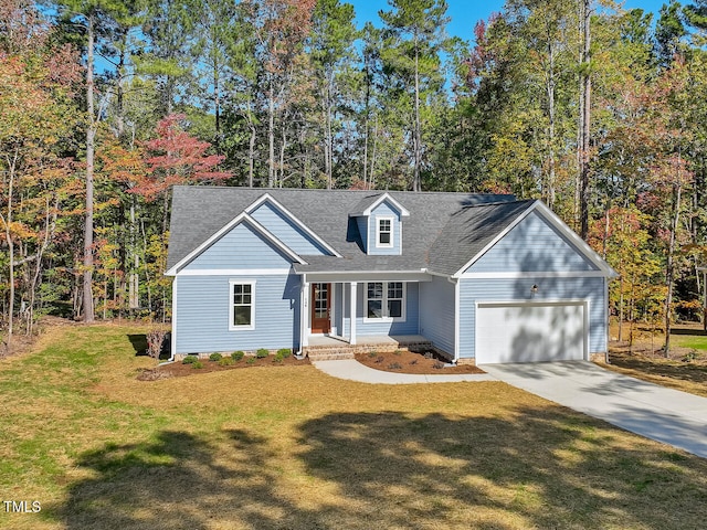 view of front of home featuring covered porch, a garage, and a front lawn