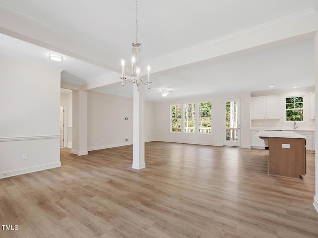 unfurnished living room with ornamental molding, light wood-type flooring, and ceiling fan with notable chandelier