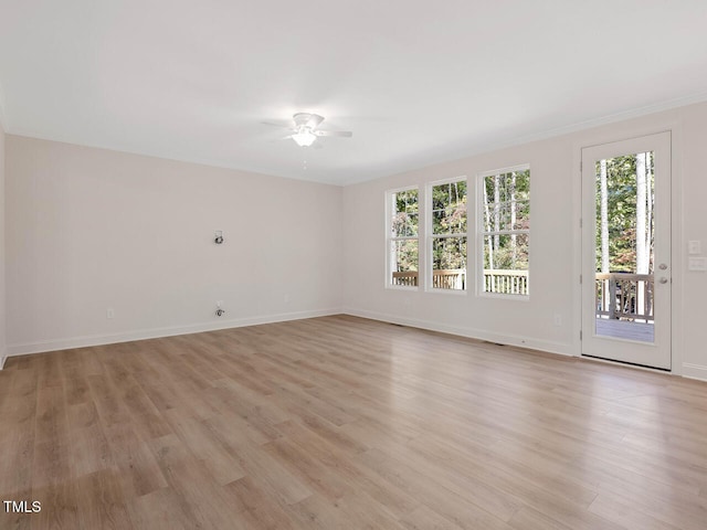 spare room featuring light wood finished floors, baseboards, and a ceiling fan