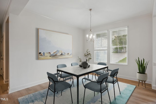 dining space featuring baseboards, a notable chandelier, light wood-style flooring, and crown molding