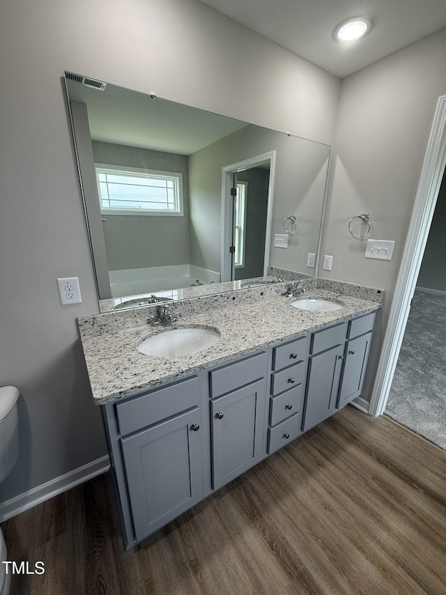 bathroom featuring vanity, toilet, and hardwood / wood-style flooring