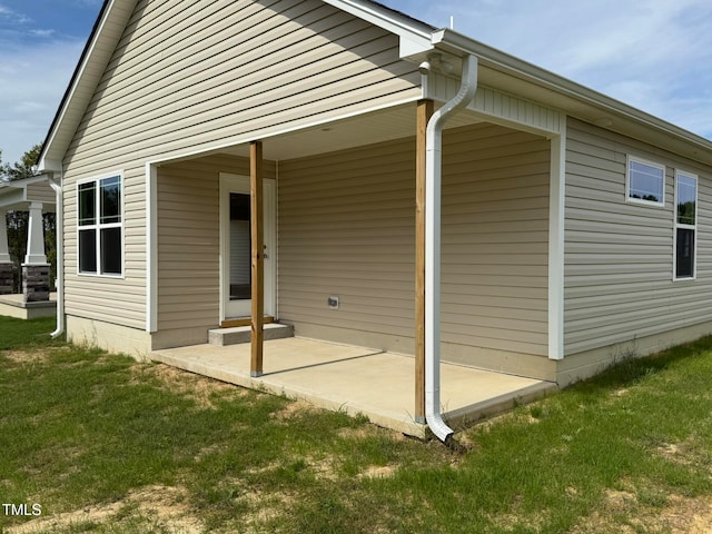 rear view of property featuring a yard and a patio