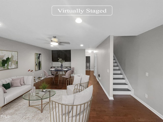 living room featuring dark wood-type flooring and ceiling fan