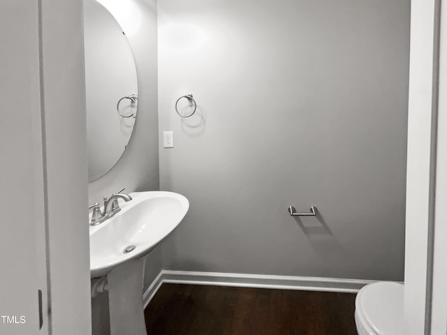 bathroom with hardwood / wood-style flooring and toilet