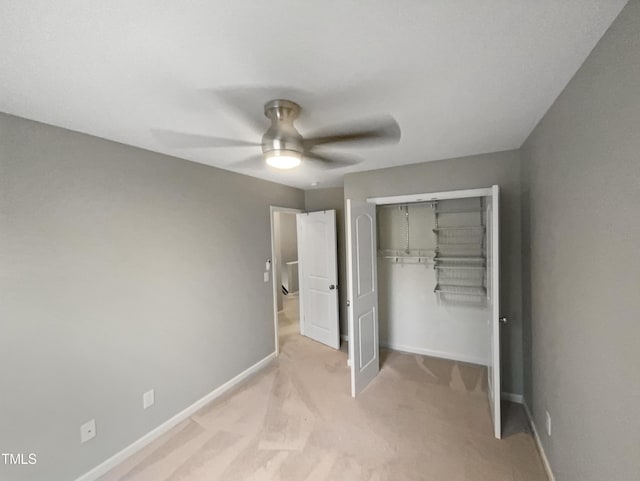 unfurnished bedroom with ceiling fan, light carpet, and a closet